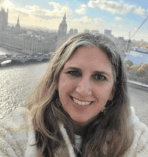 Woman smiling in front of London skyline.